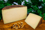 Manchego Vegamancha AOP Spanish Cheese on a cheeseboard. Half Wheel and a wedge