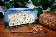 Bleu D'auvergne AOP French blue Cheese on a cheeseboard. Half a wheel.