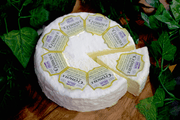 Cremeux de Bourgogne Triple cream French Cheese on a cheeseboard, full wheel and a wedge, view from above