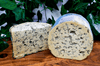 Fourme d'ambert AOP French blue cheese on a cheeseboard. Half wheel and wedge