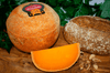 Mimolette 12 months French cheese on a cheeseboard. Full wheel and wedge