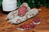 Saucisson Sec, aged French salami made with Free Range Pork, on a wooden board.